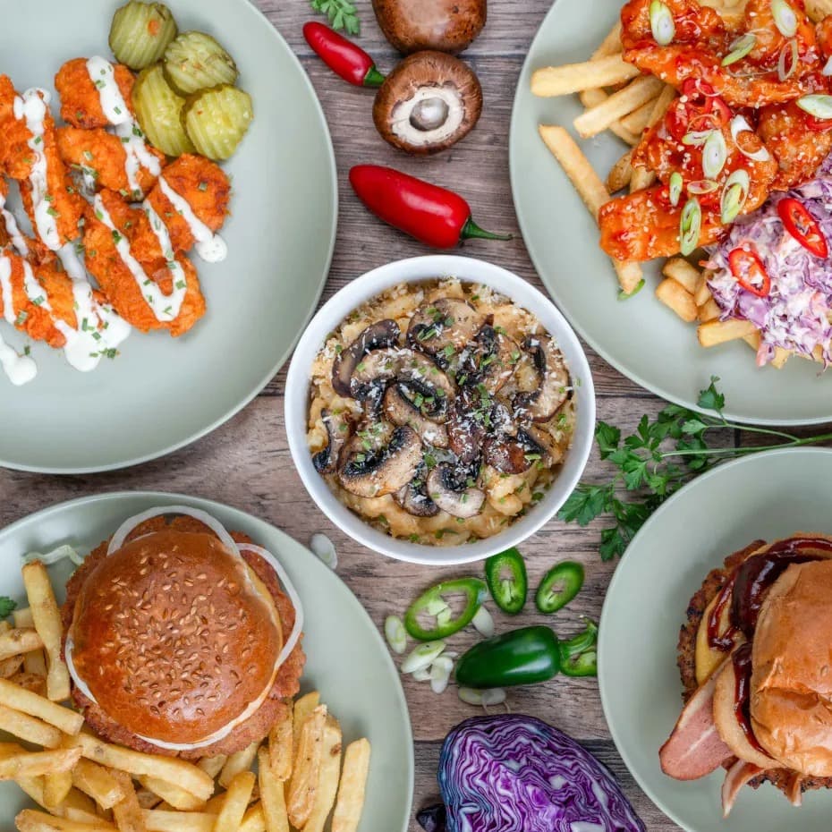 Chubby vegans spread of vegan food including hotwings, burgers, fries, mac and cheese, and more
